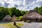 Thatch and stone cottage with Celtic cross in centre, concept of early age human settlement