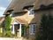 Thatched cottage with a picket fence.