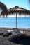 Thatched parasols on black voulcatic lava sand beach