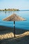 Thatched sunshade on a beach in front of old Roman fortress, Sithonia