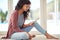 Thats interesting...a young woman using her digital tablet while sitting on the floor.