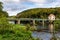 Thaya river with border bridge above, building with Czech republic flag and forest covered hill near Hardegg town on austrian -