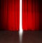 Theater red curtain slightly open with bright light behind and wood stage or scene