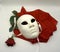 Theater or romance concept. Closeup of white classical theatrical mask and red rose as a symbol of sexual freedom