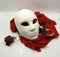 Theater or romance concept. Closeup of white classical theatrical mask and red rose as a symbol of sexual freedom