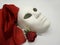 Theater or romance concept. Closeup of white classical theatrical mask and red rose as a symbol of sexual freedom