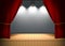 Theater stage with open red curtains and spotlights with brick wall