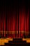 Theater stage with the red curtain and steps lit by muted light