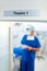 Theatre 1, where the doctor saves lives. Blurred image of a doctor wearing scrubs under a focused sign reading Theatre 1
