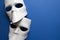 Theatre concept with the white masks on classic blue background. Anonimous, Incognito, Conspiracy concept. Place for text. Flat