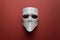 Theatre concept with the white masks on trendy terracotta background. Anonimous, Incognito, Conspiracy concept. Place for text.