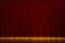 Theatrical curtain is red heavy velvet with gold fringe underneath.