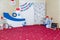 Thematic sea birthday party with wooden ship, flags, sea shells, lighthouse, steering wheel toy, paddles and soft cat in stripy T-