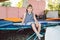 The theme of childhood, sports and health. Little boy gymnast resting in trampoline training session. A child athlete sits on a