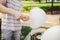 Theme is a family small business cooking sweets. Hands close-up A young male shopkeeper holding a merchant makes candy floss, fair