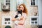 The theme is the friendship of man and animal. Beautiful young red hair Caucasian woman holding a pet dog Chihuahua breed near a