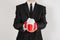 Theme holidays and gifts: a man in a black suit holds exclusive gift wrapped in red box with white ribbon and bow isolated on a