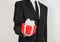 Theme holidays and gifts: a man in a black suit holds exclusive gift wrapped in red box with white ribbon and bow isolated on a