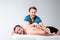 Theme massage and body care. Beautiful caucasian man in blue uniform and beard doing stretching, heals, diagnosis of back muscles