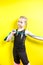 Theme sport and health. Beautiful caucasian child girl with pigtails posing yellow background with smile. little athlete holds