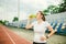 Theme is sport and health. Beautiful young caucasian woman with big breasts athlete runner stands resting on running