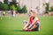 Theme sport and health. Young beautiful Caucasian woman sitting doing warm-up, warming up muscles, stretching green grass.