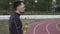 Theme sport and health. Young Caucasian male athlete runner drinking water from a sports bottle at a city stadium