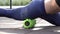 Theme sport and rehabilitation sports medicine. Beautiful strong slender Caucasian woman athlete sits next foam roller green field