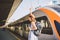 Theme transportation and travel. Portrait of young Caucasian woman with toothy smile standing at train station background with