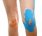 Therapeutic treatment of leg with blue physio tape