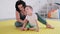 Therapist doing exercises on the mat with disabled child