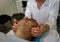 A therapist places his hands on the sides of a man`s face