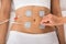 Therapist placing electrodes on woman\'s stomach