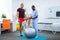 Therapist touching knee of sportsman standing near fit ball