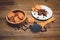 There are Cookies,Candy,Chocolate Peas,Poppy;Ceramic Plate;Tasty Sweet Food on the Wooden Background,Toned