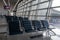 There are empty chairs, benches for passengers waiting for flights at the airport terminal, selected focus