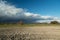 There goes a storm cloud over the field