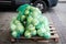 There are many sacks of cabbage on the pallet. Close-up.