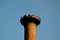 There is a metal toothed structure for the nesting of white storks on the brick historic chimney of the brewery. Brown burnt brick