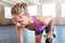 There are no gains without pains. a young woman working out with weights at the gym.