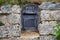 There is an old English metal mailbox built into the stone wall
