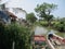 There is a pier, many boats are leaning next to housing settlements for fishermen who catch fish and shrimp