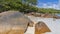 There is a pile of picturesque granite boulders on the beach.