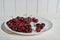 There's a bunch of cherries in the dish with space to copy. Close-up of a plate of ripe cherries in a white plate on