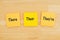 There, their, they`re on three sticky notes on textured desk wood
