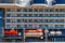 There are two orange lifeboats on the board of cruise ship. A eight floors cruise liner with orange lifeboats is in the port in