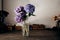 There is a vase with blue and lilac hydrangea on the wooden tabl