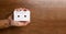 There is a white audio magnetic cassette in the man`s hand. Below is a wooden brown background. Copy Space