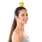 Theres only one way to reach that target...a young woman posing against a white background with an apple on her head.