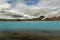 Thermal lake with incredible emerald water and smoking geysers on the background of the Icelandic landscape.